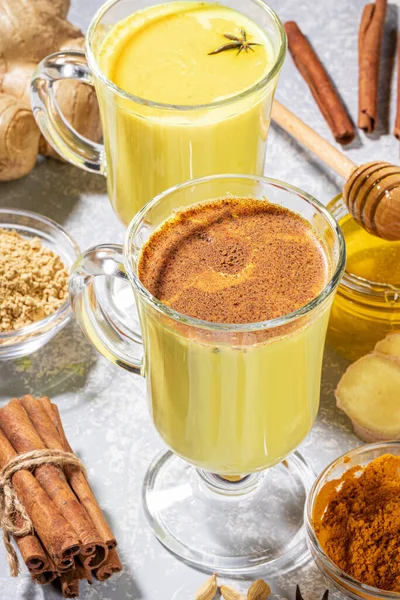Ayurvedik zerdeçal süt. Ilık şarap için iki bardak altın süt ve açık gri malzemeler..