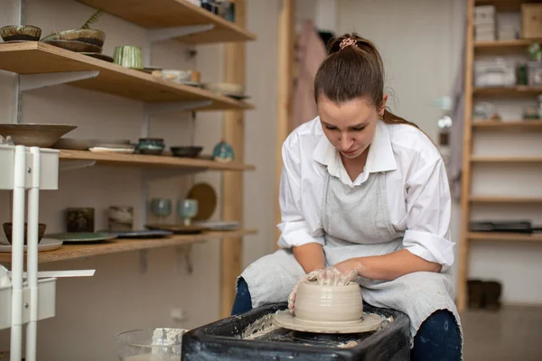 Kobieta ceramist na kole garncarza tworzy naczynia z gliny — Zdjęcie stockowe