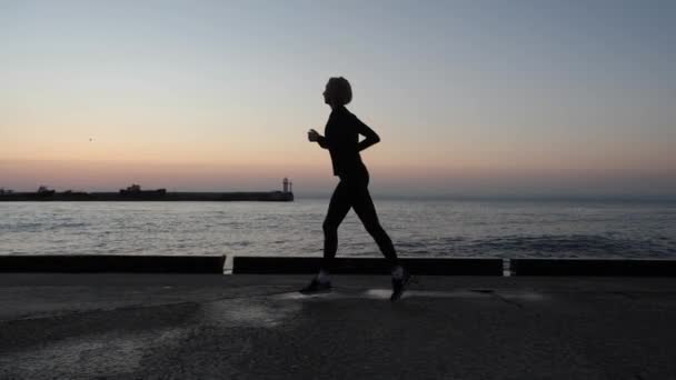 Κορίτσι αθλητής τρέχει κατά μήκος του περιπάτου. — Αρχείο Βίντεο