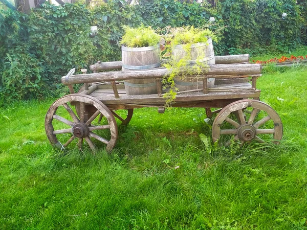 An old wooden four-wheeled chaise with barrels on it.