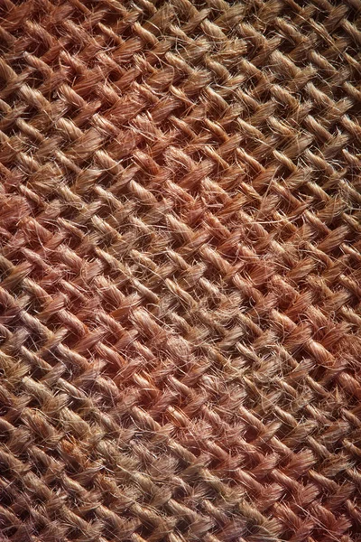 Macro texture of burlap. Brown sackcloth texture with a red tint or background from a natural brown fabric bag. Presentation concept for organic product or sackcloth crafts. For packaging — Stock Photo, Image