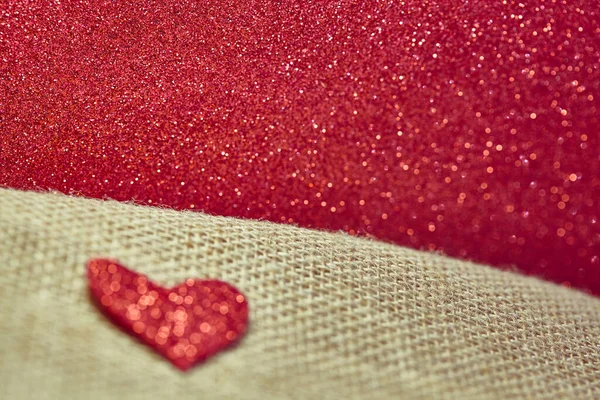 Zamazane tło czerwonego brokatu i serca. Czerwone beżowe tło na Walentynki. Brokat, serce i tkanina. Minimalizm. Czerwony obraz artystyczny, przestrzeń do kopiowania. — Zdjęcie stockowe