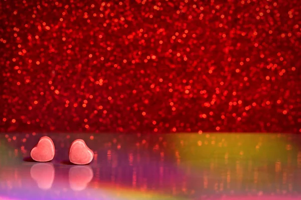 Glitter heart and bokeh. Romantic abstract valentine background. Red background with bokeh and two hearts. Valentines day concept, copy space. Valentine heart candy on a glitter background. — Stok fotoğraf