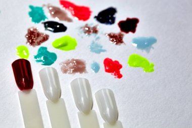 Tırnak tasarımı aşığı. Arka planda çivi uçları ve bulanık cila lekeleri var. Tırnak tasarımı için ipuçları. Arka planda birkaç tırnak cilası dökmüş. İpuçları.