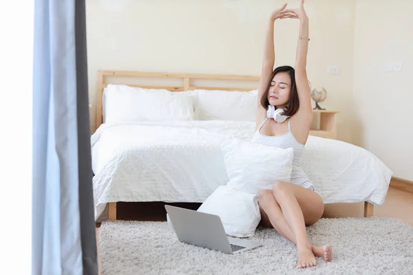 Vooraanzicht van mooie volwassen freelance Aziatische vrouw in wit overhemd werken op computer, ze neemt een pauze en stretching terwijl zittend in de slaapkamer — Stockfoto