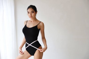 Vücudunun ölçüsünü alan sağlıklı ve zayıf bir kadın.