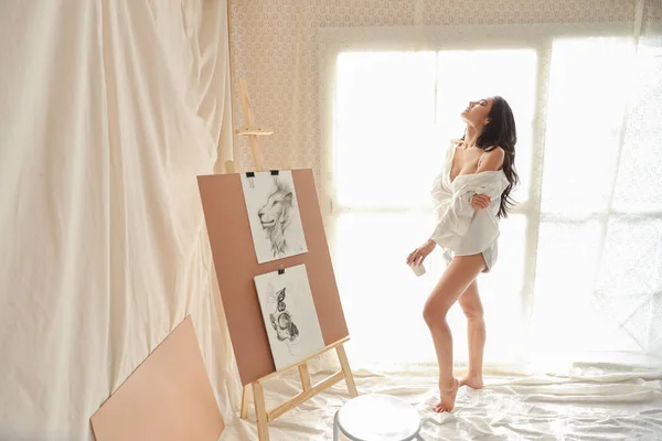 Full length ασιατική γυναίκα καλλιτέχνης σε λευκό πουκάμισο πίνοντας καφέ, ενώ σχέδιο εικόνα με μολύβι (γυναίκα έννοια του τρόπου ζωής) — Φωτογραφία Αρχείου