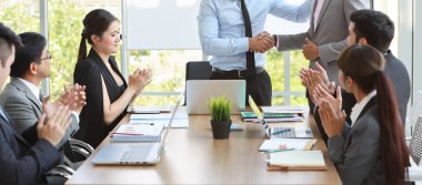 Kırpılmış görüntü uzmanı karışık yarış ekibi toplantı odasında şirket projesi üzerinde çalışıyor. İş adamları, bilgisayardaki bilgilerle birlikte beyin fırtınası yapıyor ve iş arkadaşlarıyla el sıkışarak verileri analiz ediyorlar. 