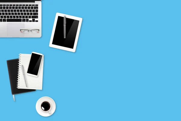 Mesa de espaço de trabalho com computador portátil, material de escritório, xícara de café, telefone celular e xícara de café no fundo pastel azul — Fotografia de Stock