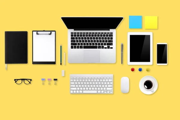 Plan plat ou vue sur le dessus bureau bureau jaune avec ordinateur portable, tasse à café et smartphone en utilisant pour arrière-plan d'affaires — Photo