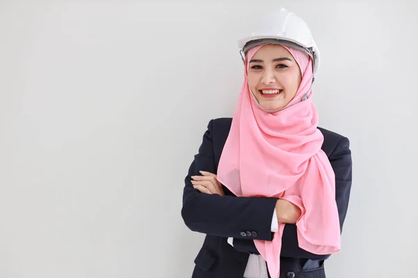 Bueautiful engineer muslim young asian woman wearing blue suit smiling confident in studio. Isolated white background portrait with beautiful face girl with pink hijab. Advertisement portrait concept. — 스톡 사진