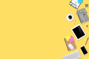 Düz çalışma masası dizüstü bilgisayarı, ofis malzemeleri, kahve fincanı, tablet ve cep telefonu sarı pastel arka planda.
