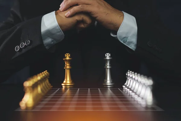 商人们手握黑色套间坐着 用老式桌上的国际象棋紧握着双手策划策略 决定和实现的目标概念 — 图库照片
