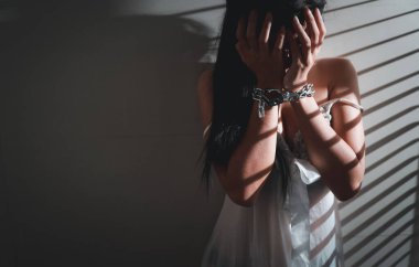 cinsel saldırı ve hapisteki Asyalı kadın beyaz iç çamaşırı giyerek hapishanede elleri zincirli yardım bekliyor. (Bu görüntü kız kurban ve şiddet konsepti için))