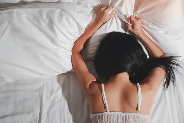 上ビュー若いと美しいアジアのセクシー女性を身に着けています白いランジェリー寝そべってベッドの上に横たわっていますセックスでベッドルーム 性的概念 — ストック写真