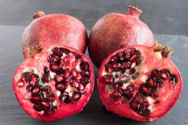 Olgun kırmızı nar ve gri bir arkaplanda tahıl.