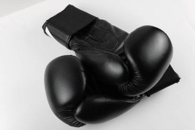 Beyaz arka plana karşı siyah boks eldivenlerinin yakın çekimi. Spor ürünleri fotoğrafçılığı