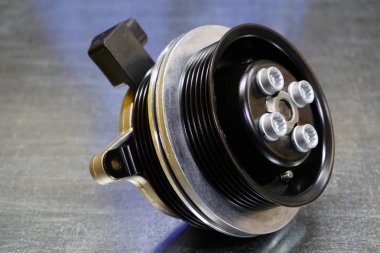 Çelik arka planda çift makaralı bir araba için yeni orijinal su pompası. Motor soğutma sisteminin detayları. Modern bir arabanın tamiri için yeni yüksek kaliteli yedek parça. Araba servisi..