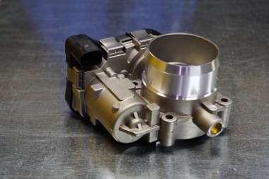 Çelik arka planda motora elektronik kontrol hava desteği sağlayan yeni yüksek kaliteli gaz vanası. Modern bir arabanın tamiri için yeni yüksek kaliteli yedek parça. Araba servisi..