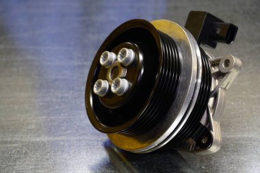 Çelik arka planda çift makaralı bir araba için yeni orijinal su pompası. Motor soğutma sisteminin detayları. Modern bir arabanın tamiri için yeni yüksek kaliteli yedek parça. Araba servisi..