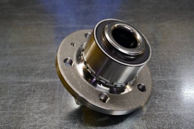 Yeni tekerlek merkezi montajı. Bu, çelik arka plandaki araba süspansiyonunun bir parçası. Yeni araba parçaları kavramı. Modern araba servisi.