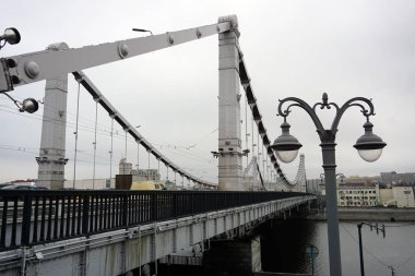 Moskova / Rusya-11 Aralık 2019: Bulutlu bir günde Kırım Köprüsü. Kırım köprüsünün büyük çelik destekleri, kablolar ve eski tarz bir sokak lambası. Kablo destekli köprü.