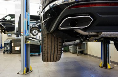 Lüks araba (SUv) bir benzin istasyonunda asansörde. Modern lüks arabaların bakım ve onarımı.