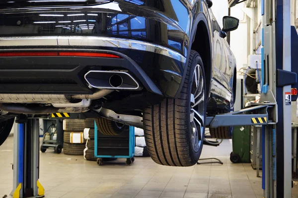 Modern lüks SUV servis merkezinde asansörde. Modern lüks bir arabanın hizmet ve onarım konsepti.                               