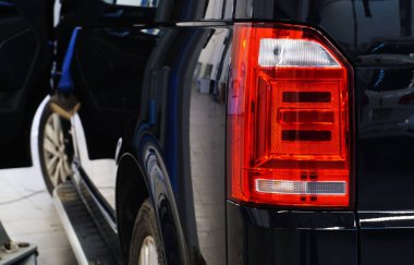 Siyah lüks araba serviste. Arka lambayı kapat. Arka plan bulanık. Modern kaliteli araba servisi kavramı. Kaliteli yedek parça kavramı.