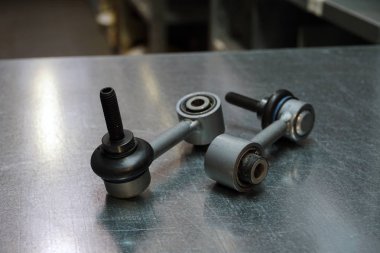 Modern bir arabanın ön ya da arka cephesinin ayrıntıları. Çelik zemin üzerinde dengeleyici çubuklar. Yeni kaliteli yedek parça. Yedek parça ticareti. Modern bir arabanın bakım ve onarımı. Kavram.                          