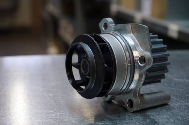 Modern bir arabanın motor parçaları. Soğutma sistemi. Çelik arka planda yeni kaliteli soğutma pompası. Yeni kaliteli yedek parça. Yedek parça ticareti. Modern bir arabanın bakım ve onarımı. 
