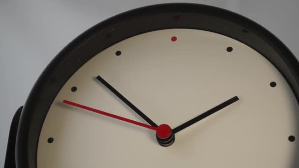 Montre classique avec un cadran blanc et trois flèches. La deuxième flèche rouge traverse la partie supérieure du cadran .