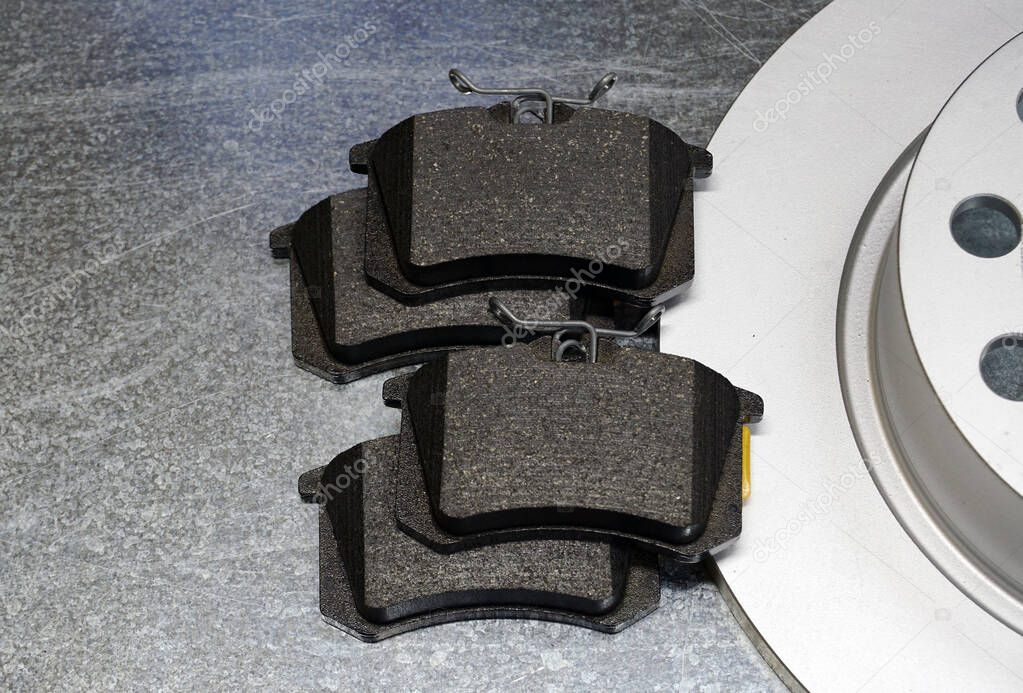 Set of brake pads of a modern car on a steel background. Quality spare parts for maintenance and repair of a modern car. Concept.