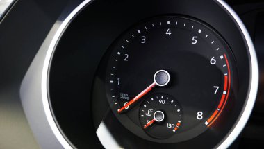 Modern bir arabanın enstrüman kümesi, dahili motor sıcaklığı göstergesi olan bir takometre, aletin kırmızı okları sıfır gösteriyor.. 