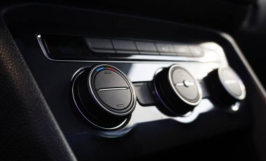 Modern bir arabanın klima kontrol ünitesi. Anahtarlar ve kontroller. Kontrol tuşlarından birine odaklan, arkaplandaki diğer tuşlar bulanık. Modern lüks bir arabanın iç mimarisi ve tasarımı..                               