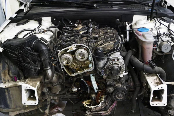 Modern güçlü motor tamir ediliyor. Motor arabanın üzerine monte edildi, zamanlama kapağı motordan çıkarıldı. Zamanlamanın kısımları fotoğrafta görülebilir: faz düzenleyiciler, zincirler, gericiler.