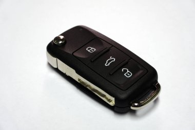 Beyaz arka planda izole edilmiş modern bir arabanın üç tane hırsızlık önleyici sistem kontrollü yeni kontak anahtarı. Modern taşımacılığın yedek parçaları ve teknolojileri.