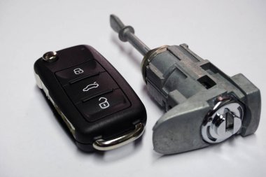 Modern bir araba için üç düğmeli yeni kontak anahtarı ve beyaz arka planda yeni bir silindir kilit. Aracın güvenliğini ve güvenliğini sağlıyorum. Kaliteli parçalar.