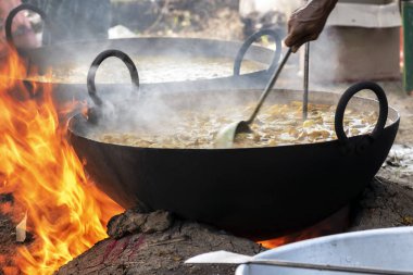Yerli topluluklardan birinde, birçok insanın yemesi için yemek pişirilmesi düzenleniyor.