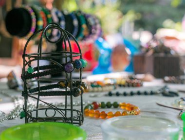 Beyaz bir masada renkli mücevherler ve süslemeler.