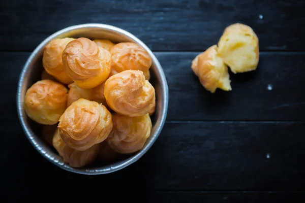 Puffs de creme no fundo de madeira . — Fotografia de Stock