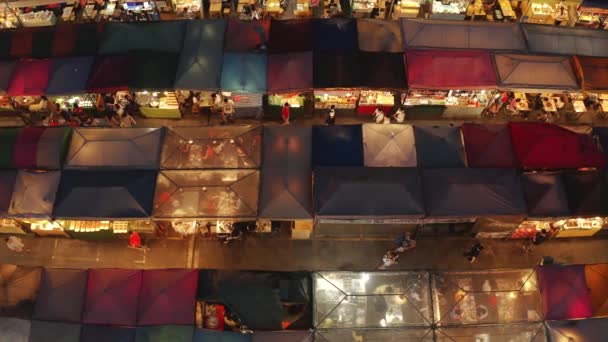Снимки с воздуха, идущие вдоль рядов ларьков на железнодорожном рынке Рачада, Бангкок — стоковое видео