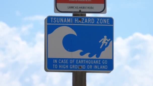 Close up of a sign indicating Santa Monica Beach as a tsunami and earthquake hazard zone — ストック動画