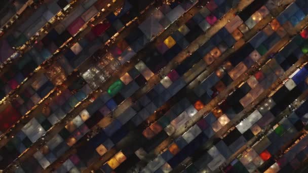 Descending rotating aerial shot of Rachada Train Market, Bangkok, at night — 비디오