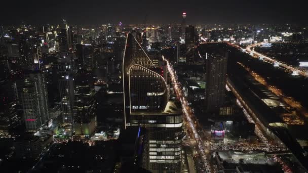 Стрельба беспилотника на орбите небоскребов и железнодорожного вокзала Бангкока ночью — стоковое видео