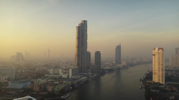 Drónlövés panning a Chao Phraya folyó egy bangkoki városkép napkeltekor — Stock videók