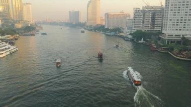 İHA, güneş doğarken Bangkok 'taki Chao Phraya Nehri boyunca bir su taksisini takip ederken ateş etti.