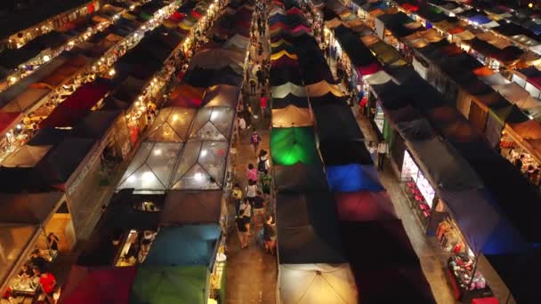 Rastreamento de tiros de drones ao longo de fileiras de barracas no Mercado Noturno de Rachada, Bangkok — Vídeo de Stock