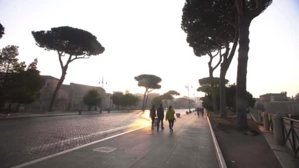 İnsanlar şafak vakti Roma 'da Via dei Fori Imperiali' de yürüyorlar. — Stok video