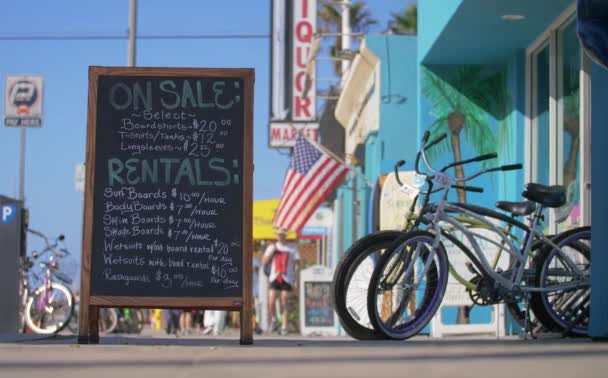 Sign advertising proces for wetsuit, surfboar and skateboard rental in LA, California near Venice Beach — Stock Video